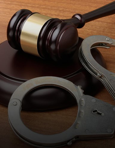 A wooden gavel rests on a sound block beside handcuffs, symbolizing the work of Louisiana immigration lawyers.