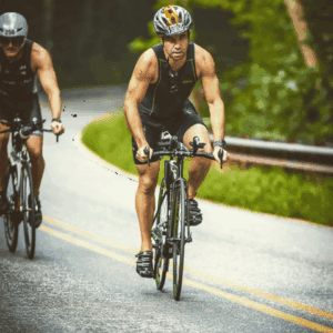 Two cyclists ride a curving road surrounded by greenery, wearing helmets—much like personal injury lawyers Louisiana focused on safety.