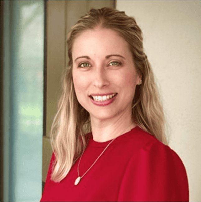 Woman with long blonde hair in a red top, smiling near a window—perfect for personal injury lawyers Louisiana profiles.