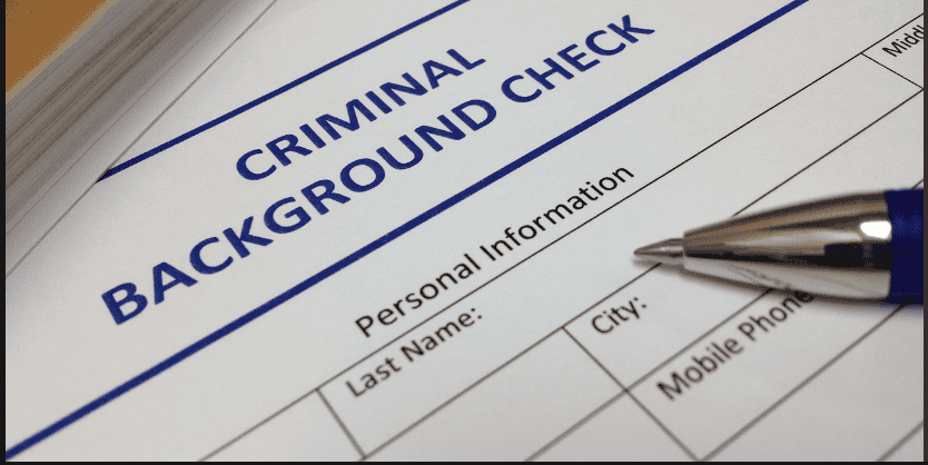 A pen rests on a criminal background check form, often reviewed by Louisiana immigration lawyers for vital personal information.