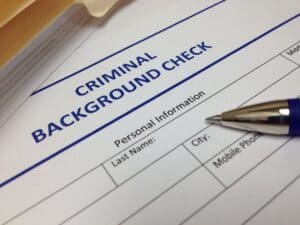 A pen rests on a criminal background check form, essential for immigration visa lawyers assisting with personal information requirements.