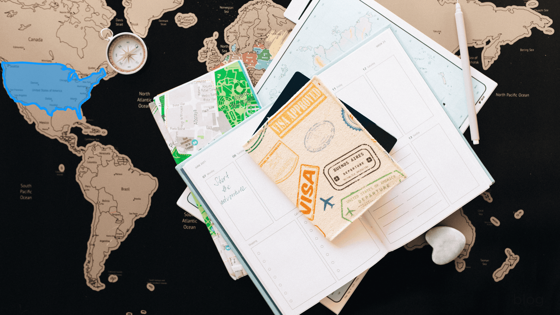 A travel-themed flat lay with a world map, planner, notebook, pen, compass, and passport—ideal for immigration visa lawyers planning journeys.