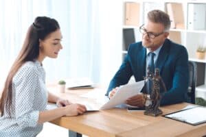 A woman and a male lawyer in business attire reviewing documents about work visa options