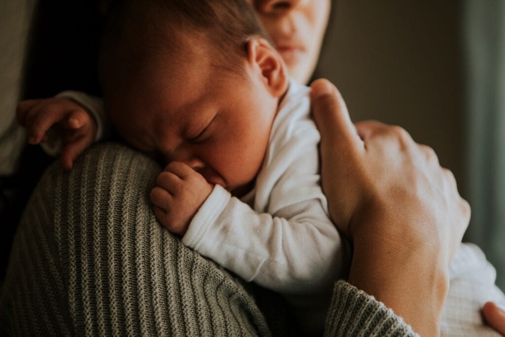 Madre sosteniendo a su bebé dormido