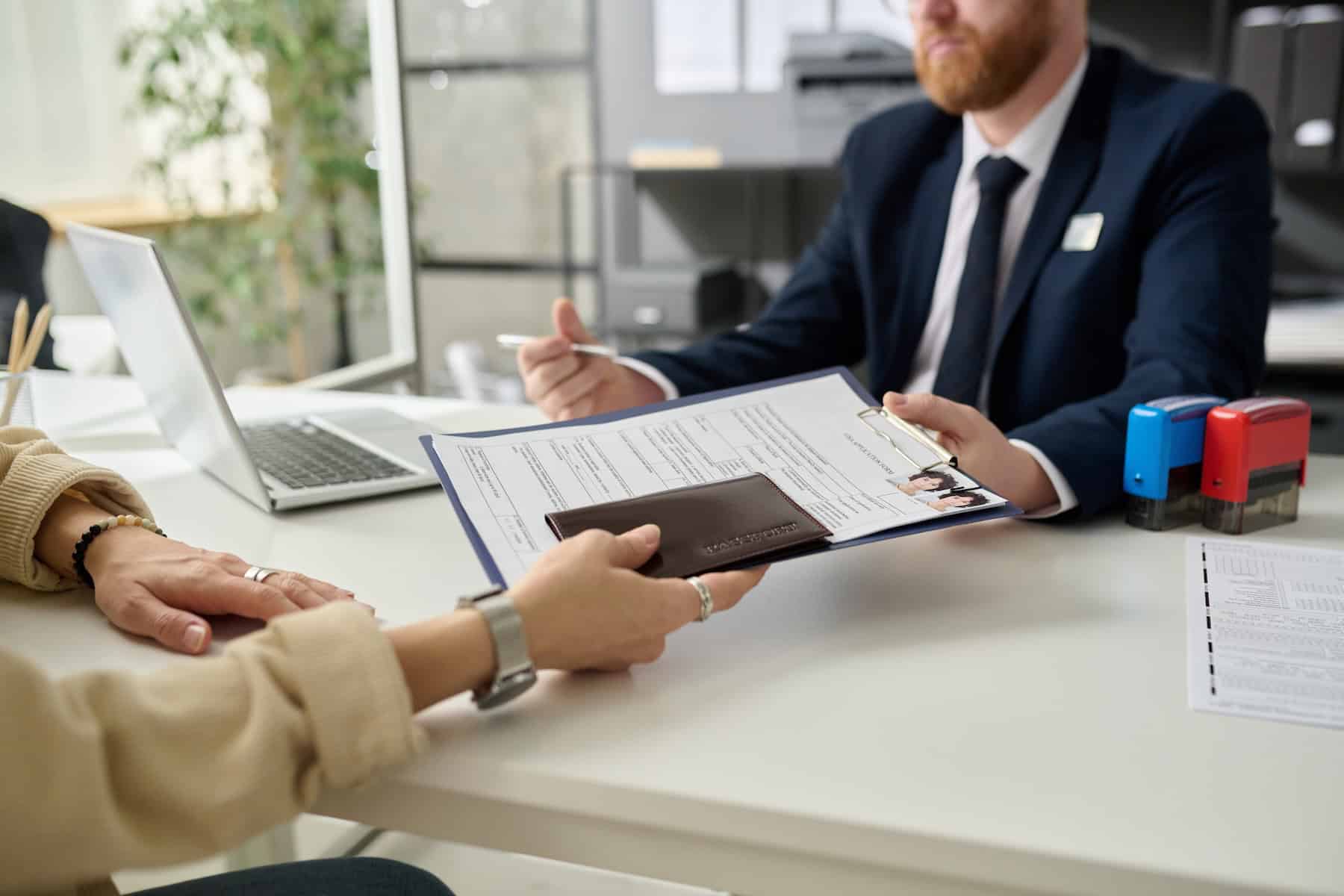 Close up of woman applying for visa in US immigration office and handing documents